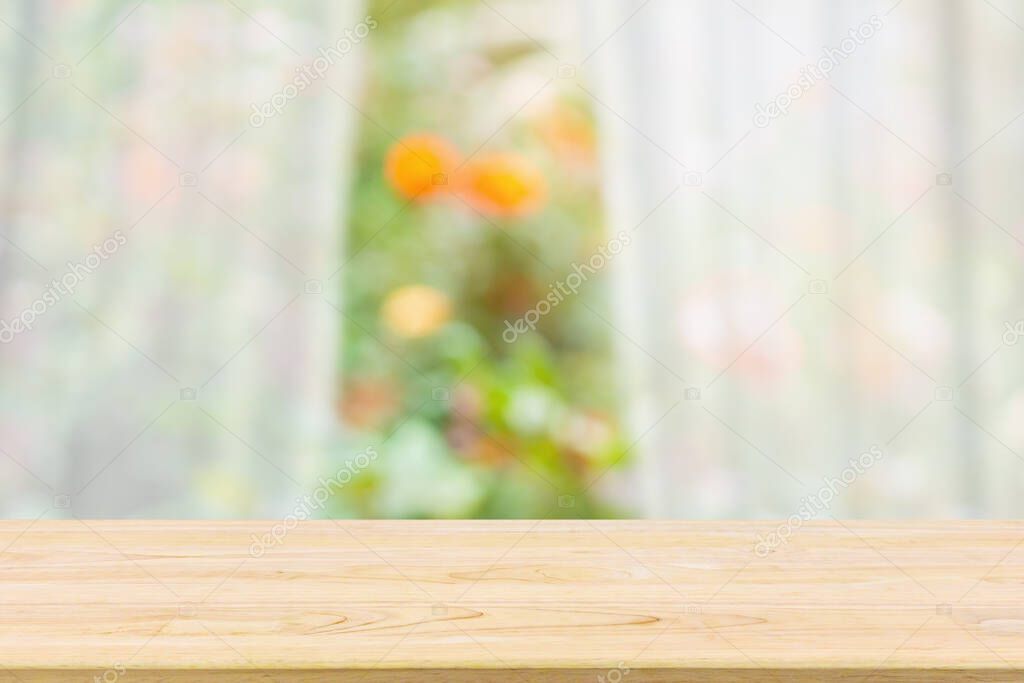 Empty wood table top with blur white curtain window and green garden background for product display template
