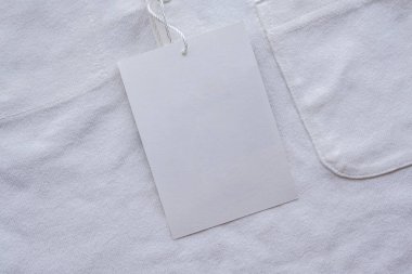 Yeni gömlekte boş beyaz kıyafet etiketi etiketi
