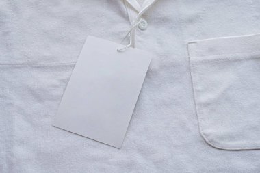 Yeni gömlekte boş beyaz kıyafet etiketi etiketi