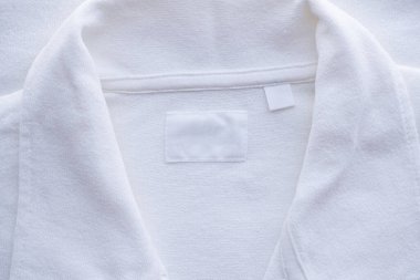 Yeni gömlek arka planında boş beyaz giysi etiketi