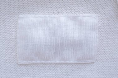 Yeni gömlek arka planında boş beyaz giysi etiketi
