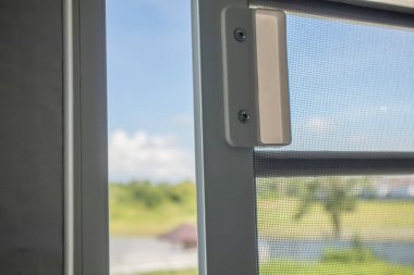 Ev penceresinin böceklere karşı korunması için sivrisinek ağı ekranını aç