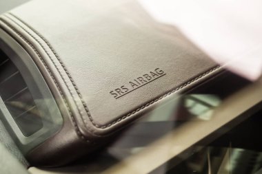 Modern arabanın kahverengi deri dokusunda hava yastığı güvenlik işareti var.