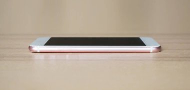 Ahşap masadaki mobil akıllı telefon