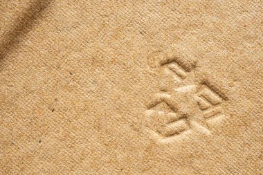 Kahverengi karton kağıt doku arkaplanındaki geri dönüşüm işareti