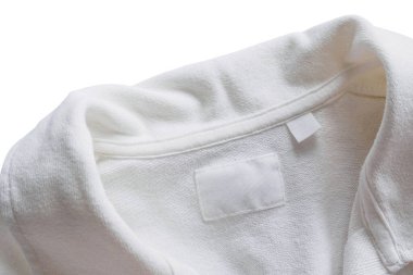 Yeni pamuk gömlek arka planında boş beyaz giysi etiketi