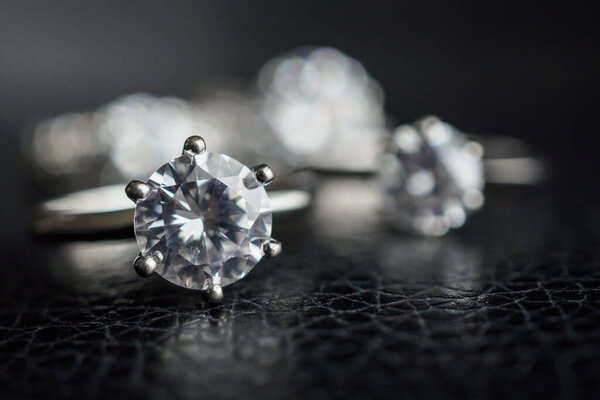 Close up diamond rings jewelry on black leather background