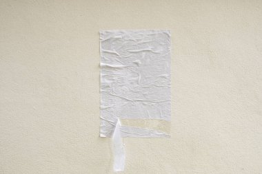 Boş beyaz buruşmuş ve buruşmuş. Beton duvar arka planında yapıştırıcı sokak posteri modeli.