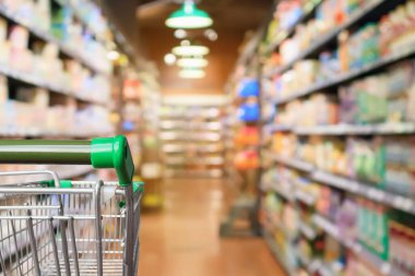 Boş yeşil süpermarket alışveriş arabası soyut bulanık market koridoru odaklanmış arka plan