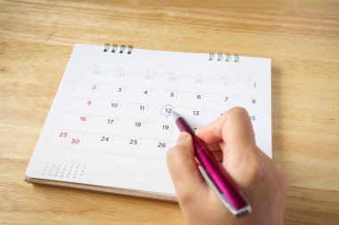 Takvim sayfası masa üzerinde kadın eli kalem, üst görünüm