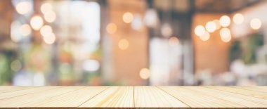 Boş ahşap masa üstü, restoran kafesi ya da müşteri bulanıklığı olan kahve dükkânı içi montaj ürün görüntüleme arka planı için soyut vintage stil bokeh ışığı