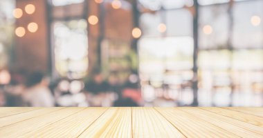 Boş ahşap masa üstü, restoran kafesi ya da müşteri bulanıklığı olan kahve dükkânı içi montaj ürün görüntüleme arka planı için soyut vintage stil bokeh ışığı