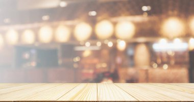 Ahşap masa üstü restoran kafesi ya da kafenin içi soyut odaklanmış bulanık arka planı olan insanlarla dolu.