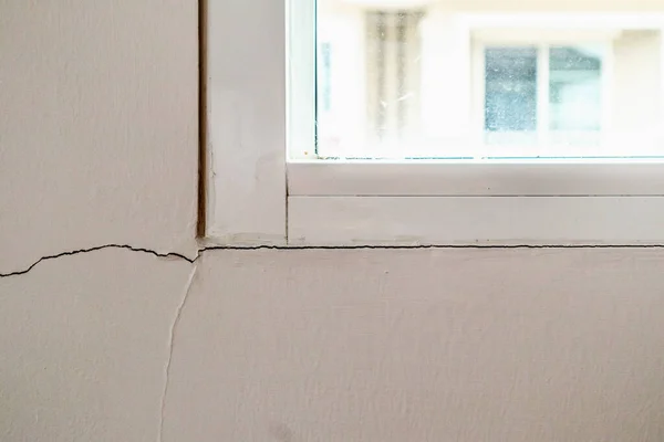 Pencere çerçevesinin yanında yeni bir duvar çatlağı