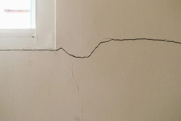 Pencere çerçevesinin yanında yeni bir duvar çatlağı