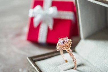 Kırmızı hediye kutusu geçmişi olan pembe elmas bir yüzük.