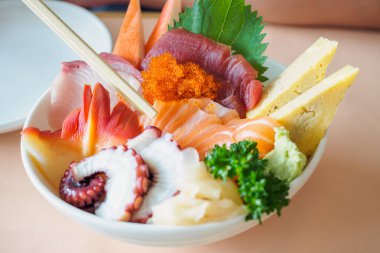 Çubuklarda somon dilimi, Sashimi Rice Bowl Chirashi Don Japon yemeği.