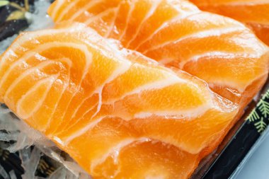 Taze somon balığı, tabakta dilimlenmeye hazır.