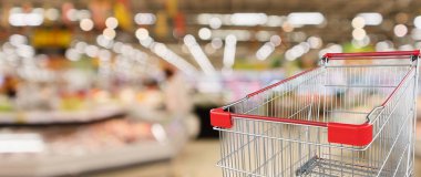 Meyve ve sebze raflarıyla süpermarket içi boş kırmızı alışveriş arabasıyla boşaltılmış arka plan