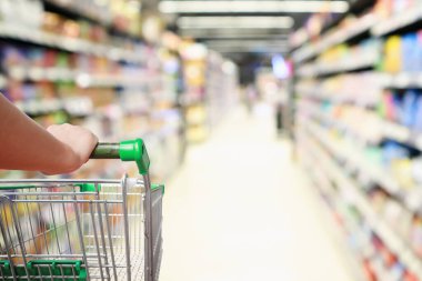 Kadın el arabası soyut bulanık süpermarket koridoru odaklanmış arka plan