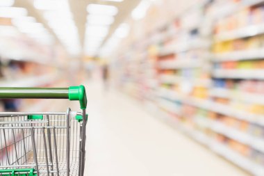 Boş yeşil süpermarket alışveriş arabası soyut bulanık market koridoru odaklanmış arka plan