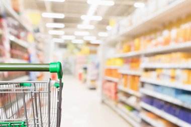 Boş yeşil süpermarket alışveriş arabası soyut bulanık market koridoru odaklanmış arka plan