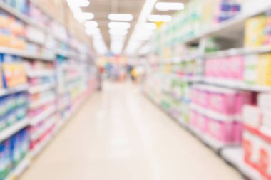 Bulanık süpermarket koridoru ve çeşitli tuvalet kağıdı görüntüleriyle dolu raflar