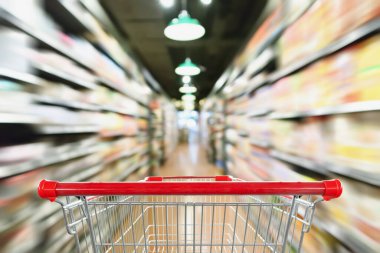 Soyut bulanık süpermarket indirim mağazası koridoru ve ürün rafları olan boş alışveriş arabası.
