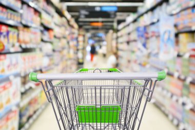 Boş alışveriş arabalarıyla dolu süpermarket rafları. Odaklanamayan iç görünüm bokeh ışık arka planı.