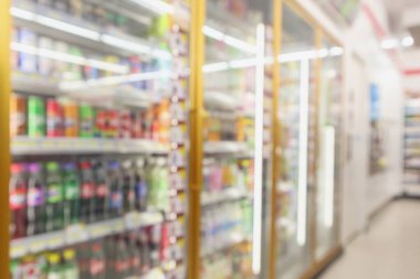 Marketteki buzdolabı raflarındaki meşrubat şişeleri arka planda bulanık