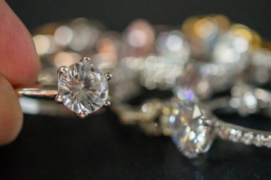 El ele tutuşan elmas yüzükler siyah arkaplanda yakın plan