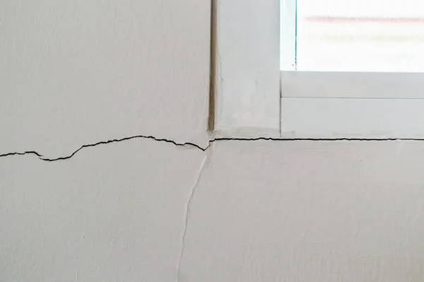 Pencere çerçevesinin yanında yeni bir duvar çatlağı