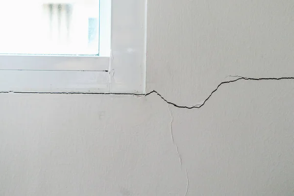Pencere çerçevesinin yanında yeni bir duvar çatlağı