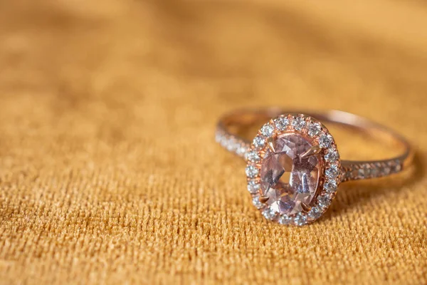 金织物背景上的珠宝粉红钻石戒指 — 图库照片