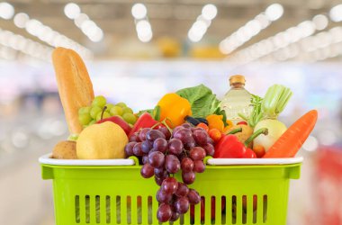 Meyve ve sebzelerle dolu alışveriş sepeti süpermarket marketi ile bulanıklaştırılmış arka plan bokeh ışığı ile bulanıklaştırılmış