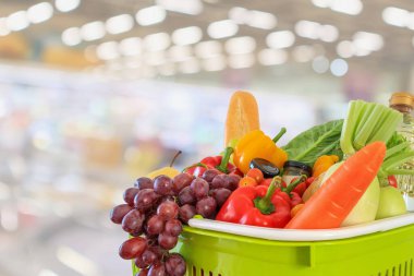 Meyve ve sebzelerle dolu alışveriş sepeti süpermarket marketi ile bulanıklaştırılmış arka plan bokeh ışığı ile bulanıklaştırılmış