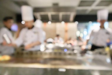 Lokanta mutfağında aşçı bulanık arka planda kalmış.