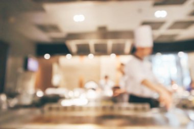 Lokanta mutfağında aşçı bulanık arka planda kalmış.