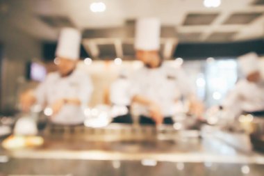 Lokanta mutfağında aşçı bulanık arka planda kalmış.