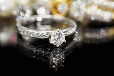 Siyah arka planda yansıması olan lüks mücevher yüzükleri.