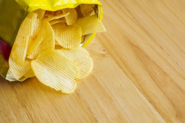 Tahta masada patates cipsi açık.