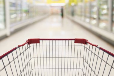 Boş kırmızı alışveriş arabası manzarası süt ve yoğurt rafları süpermarkette koridor