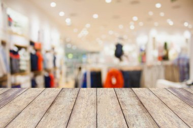 Bokeh arkaplanı olan boş masa ve bulanık giyim mağazası, ürün gösterimi