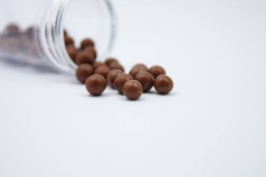 Beyaz arka planda şişesi olan alternatif ilaç hapları.