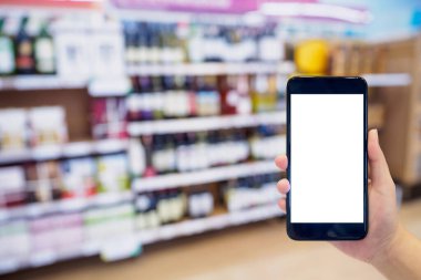 Süpermarketin arka planında şarap raflarıyla el ele tutuşan akıllı telefon