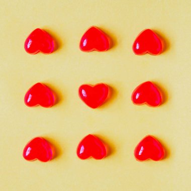 Sevgililer Günü arkaplanında kırmızı kalp şeklinde şekerler ve sarı arka planda