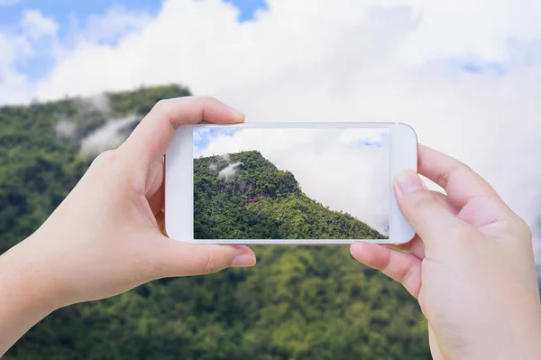 Female using mobile smart phone Taking photo of Beautiful landscape in the mountains