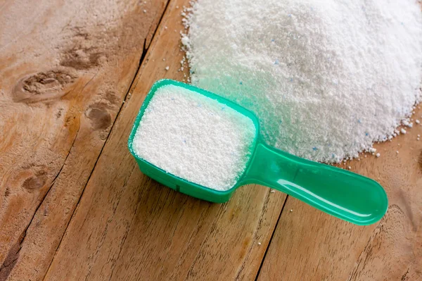 Deterjan tozu, deterjan deterjan, tahta arka plandaki kaşık.