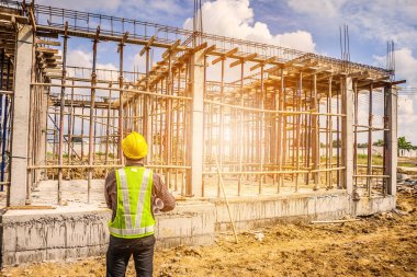 Asyalı işadamı inşaat mühendisi koruyucu miğfer ve bina inşaatında kullanılacak planlar.