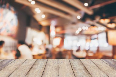 Kafedeki restoran masası ya da kahve dükkanının iç tarafındaki insanlar bulanık arka planda soyutlanmış.